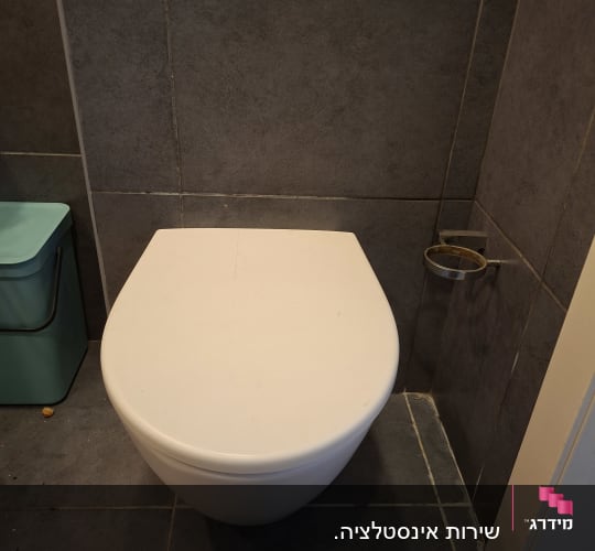 אסלה בחדר אמבטיה עם קירות אפורים